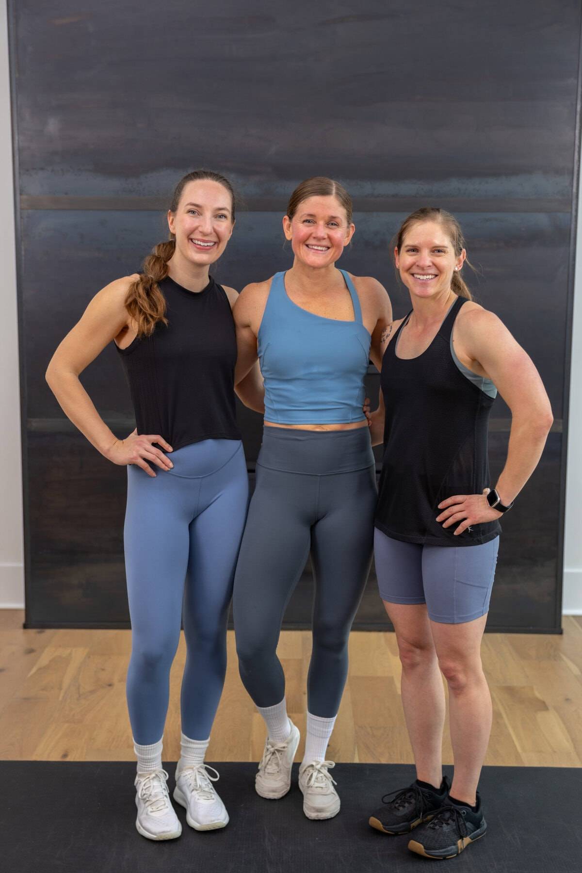 2 women smiling next to US marine as part of marine workout