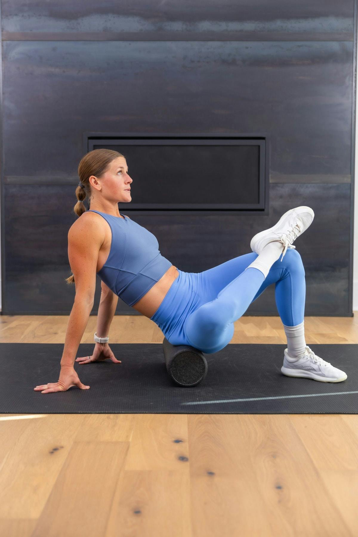 woman foam rolling as part of a muscle recovery routine