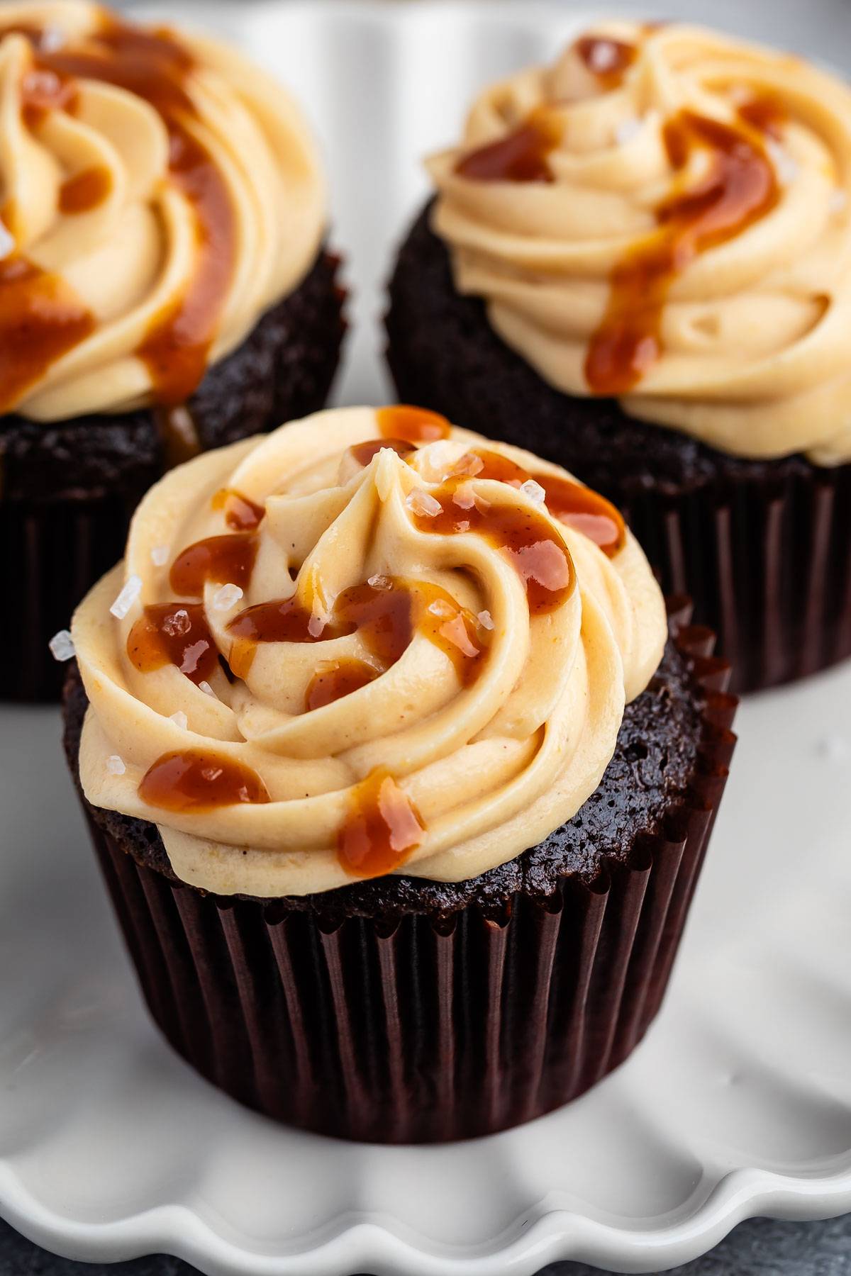 tan frosting on a brown cookie with caramel drizzled over.