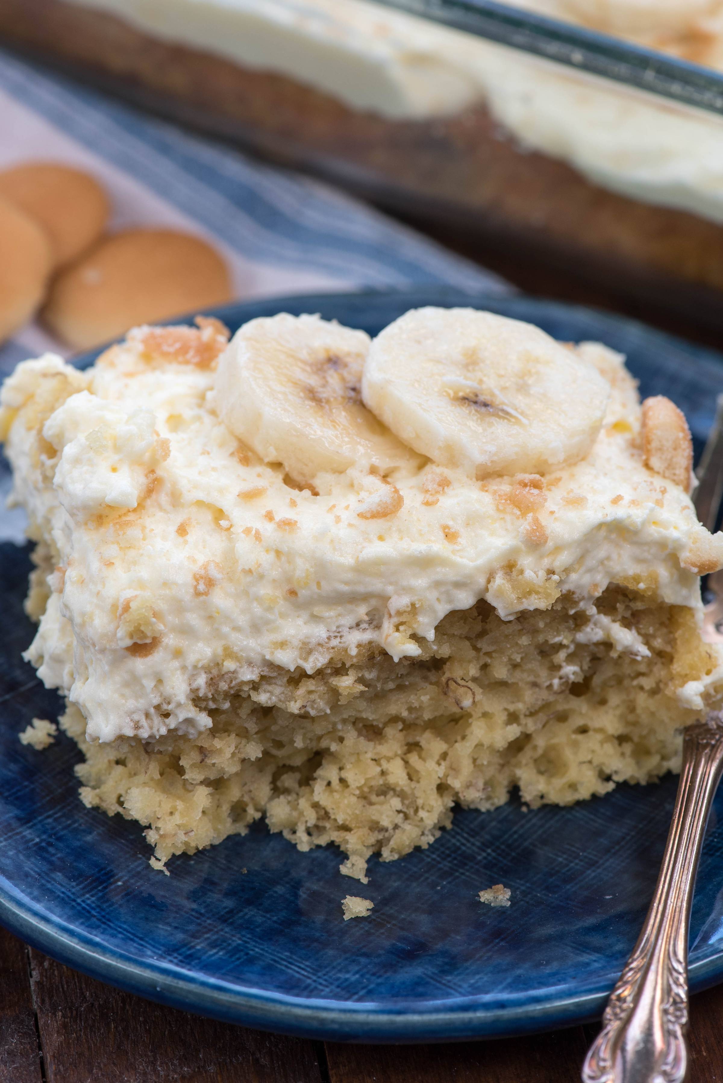 square slice of banana pudding cake with sliced bananas on top.