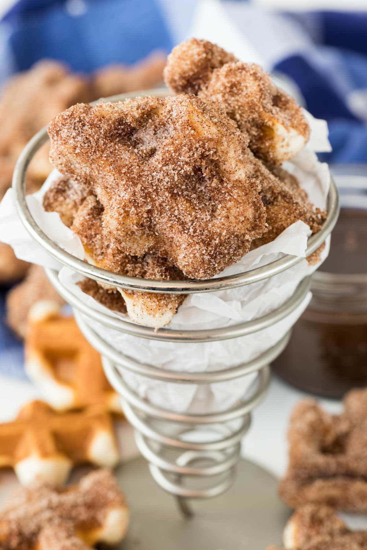 churro bites mixed together in a metal cup.