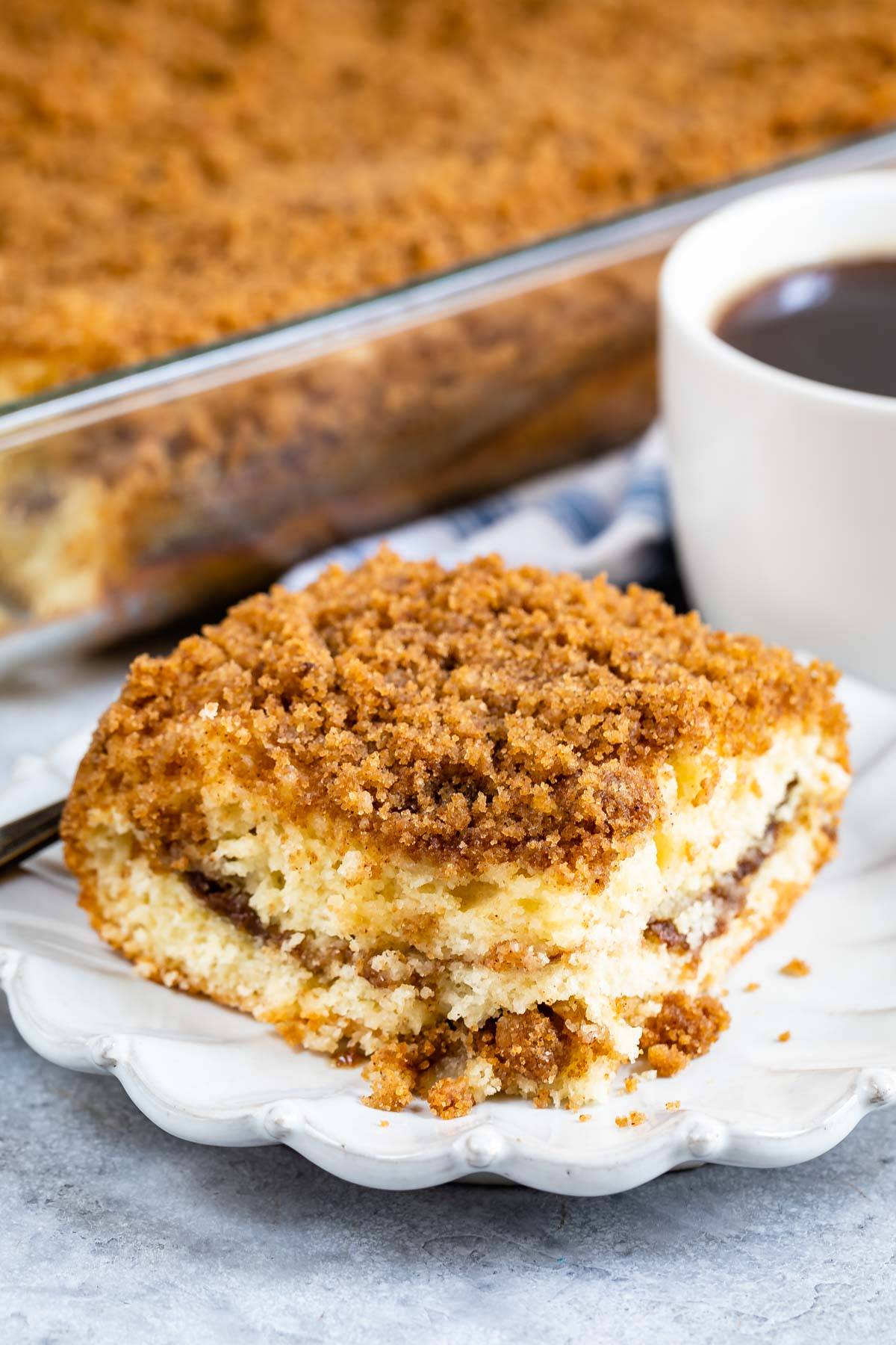 one slice of coffee cake on a grey plate with streusel crumble topping on top. 