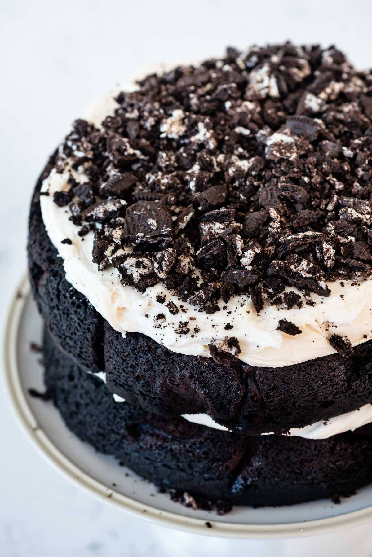 layered oreo cake with white frosting and crushed oreos on top.