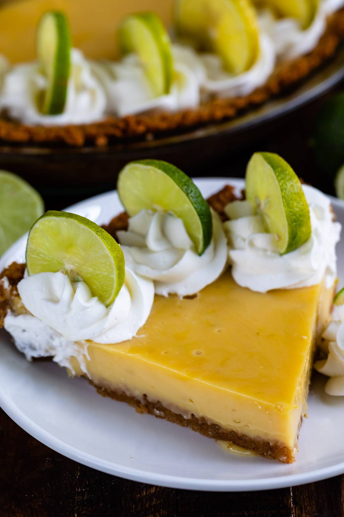 one triangle slice on yellow pie with lime slices on the edge.