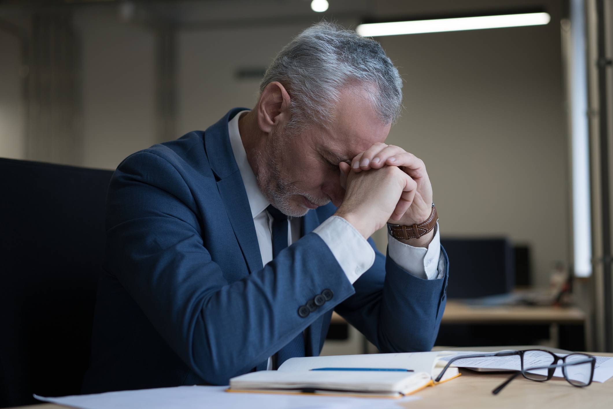 Mentally stressed older businessman at work