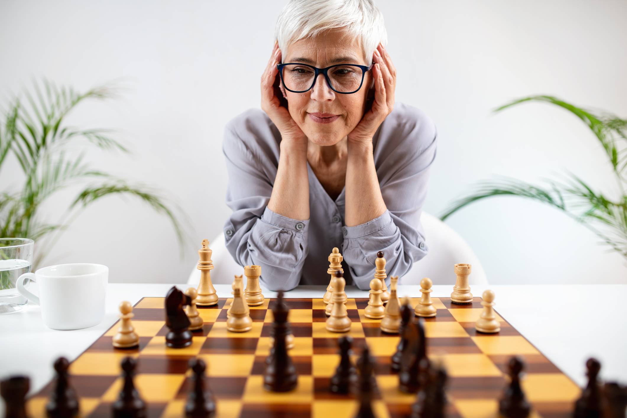 older woman focusing on a chess board