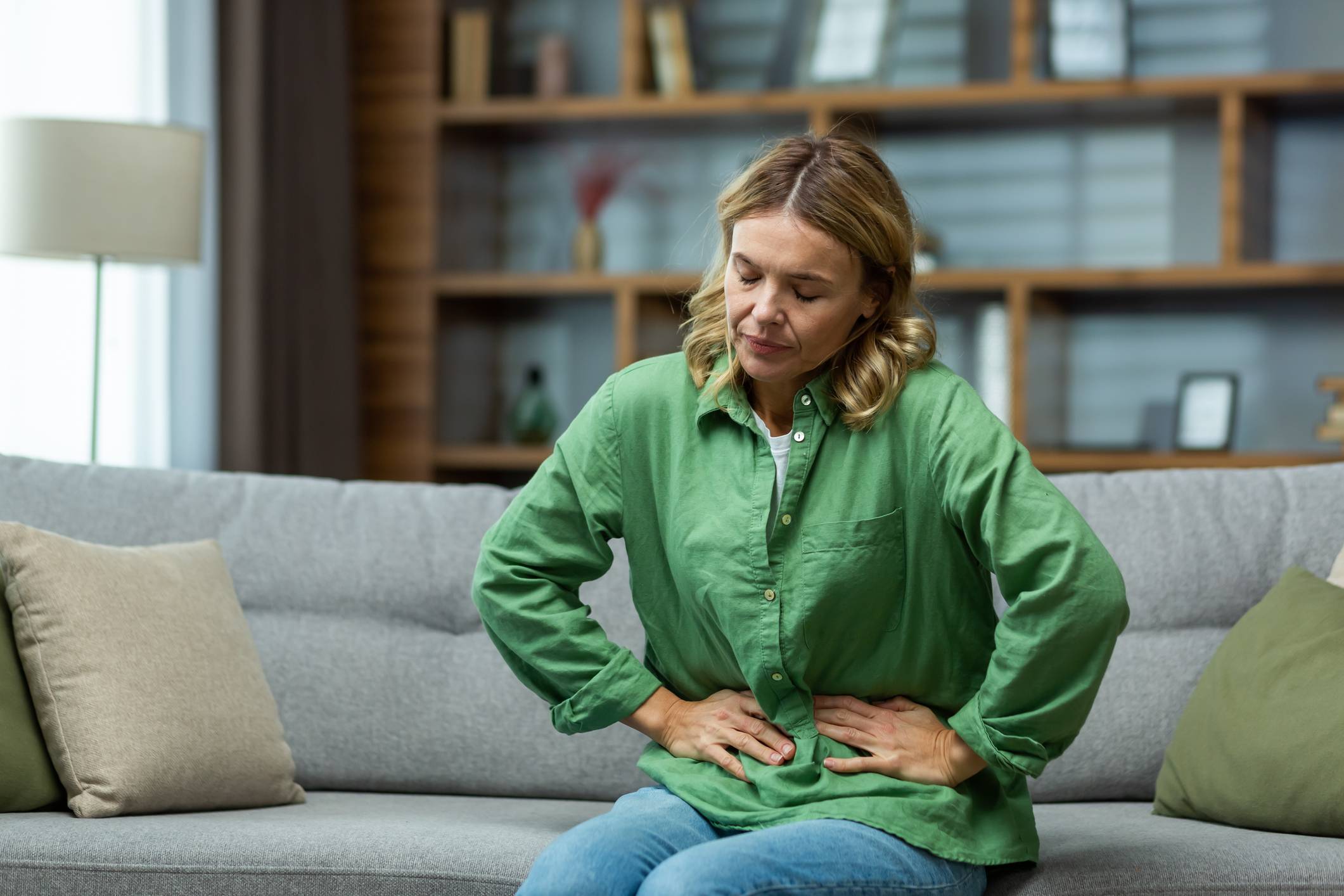 Middle-Aged woman holding her stomach in discomfort