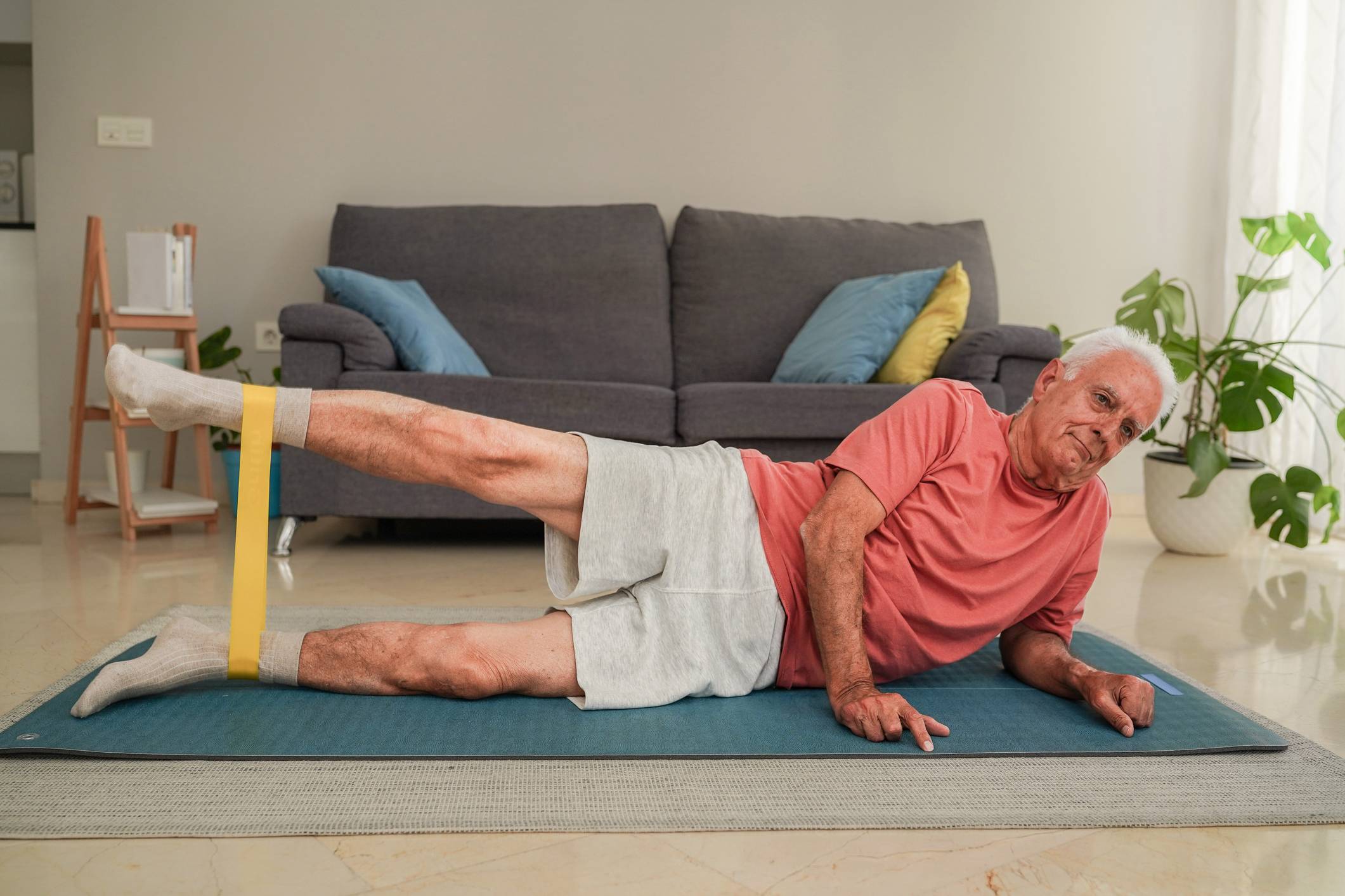 senior man working with resistance bands on a yoga mat