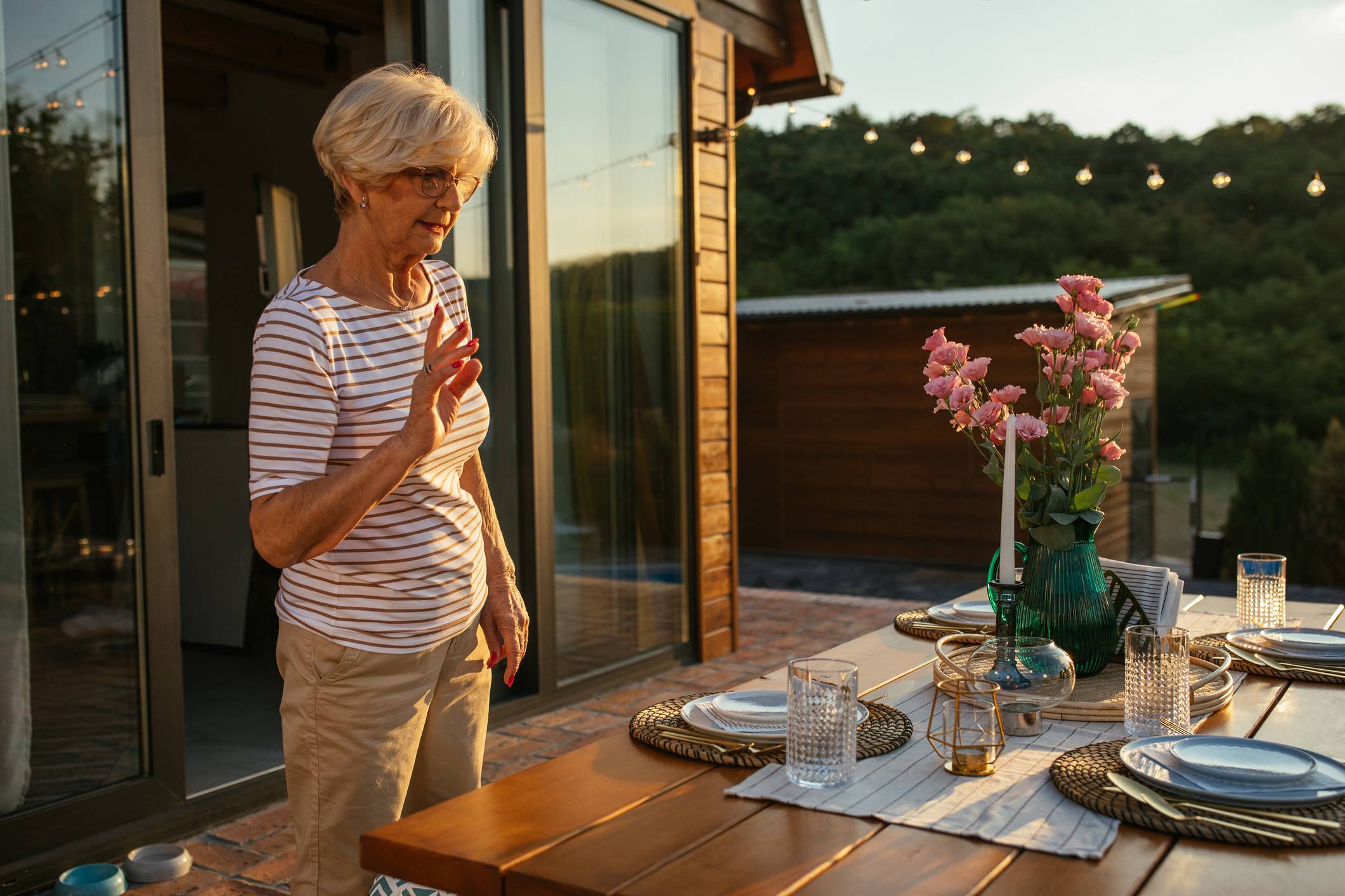 Senior woman preparing an outdoor table for guests