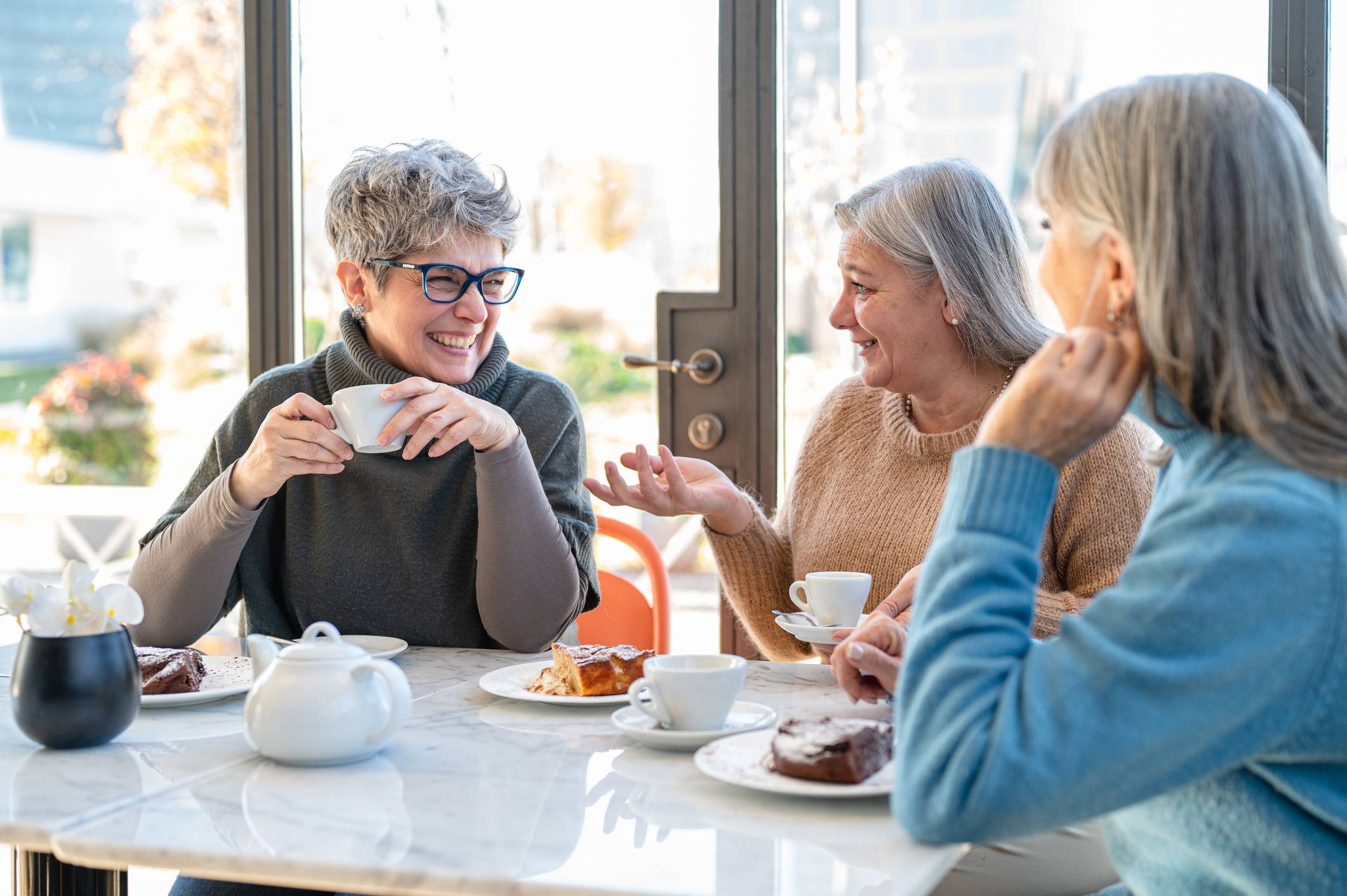 older women smiling and conversing over breakfast