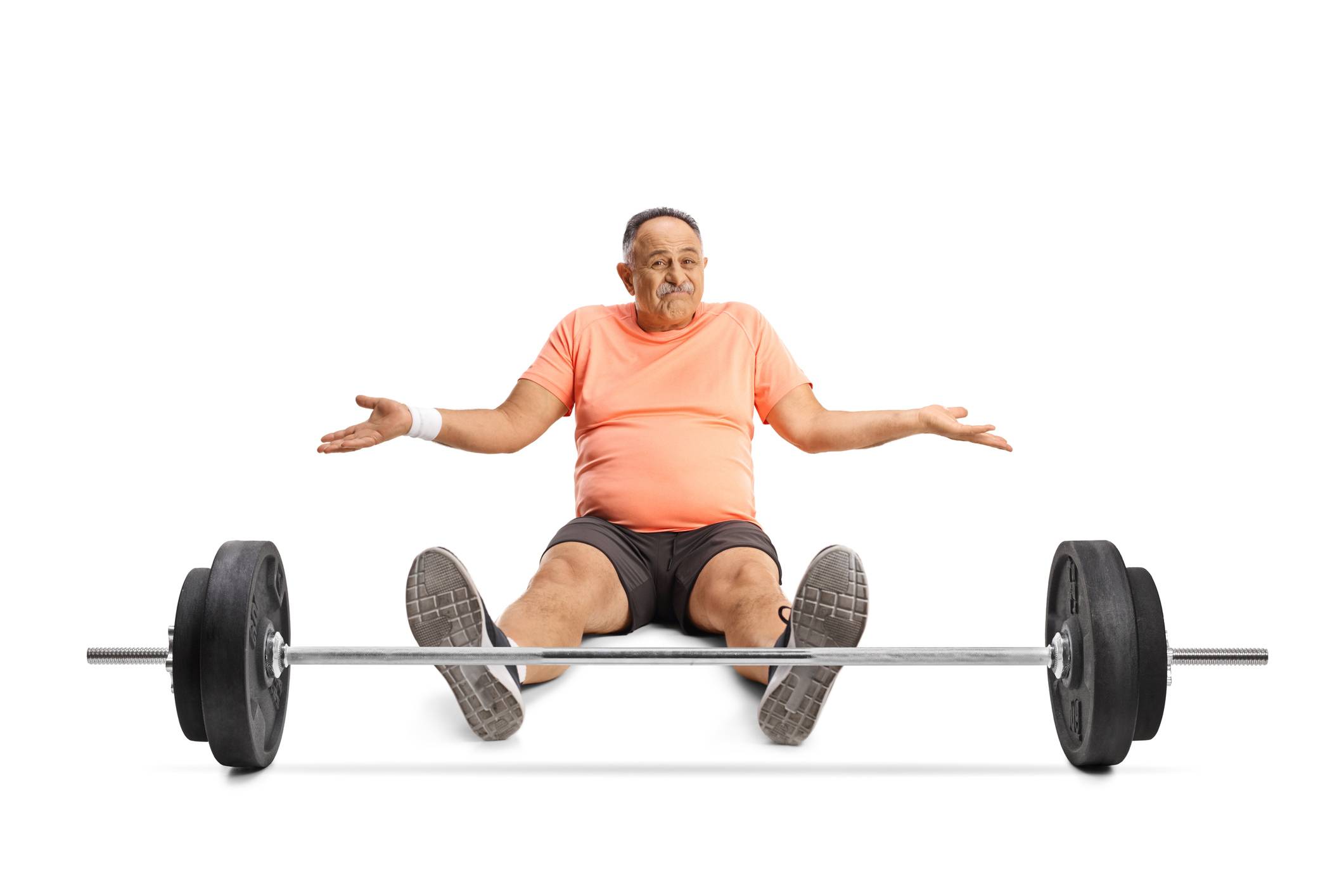older man sitting on floor in front of barbell
