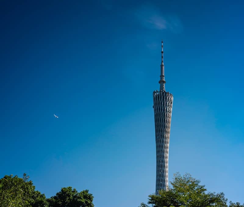 The canton tower soars against a bright blue sky.