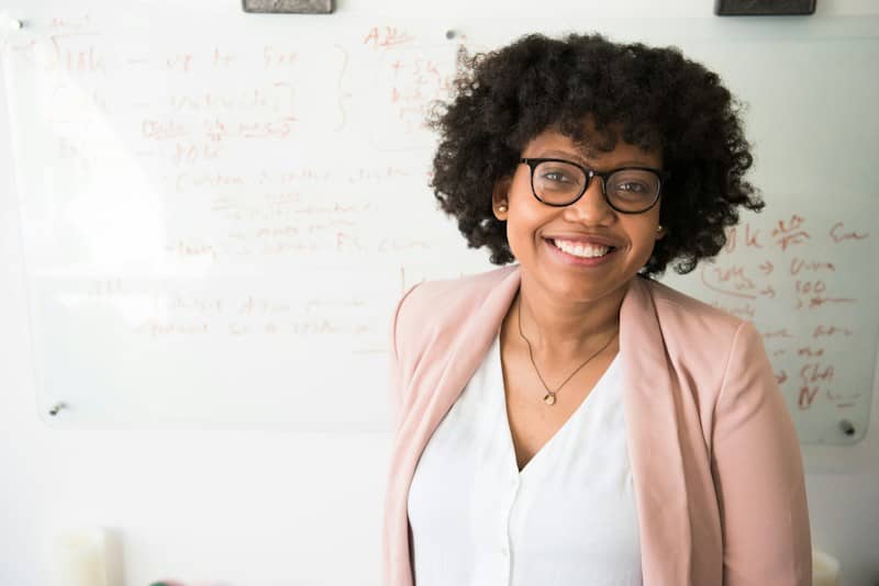 Smiling Black woman with short curly hair and glasses