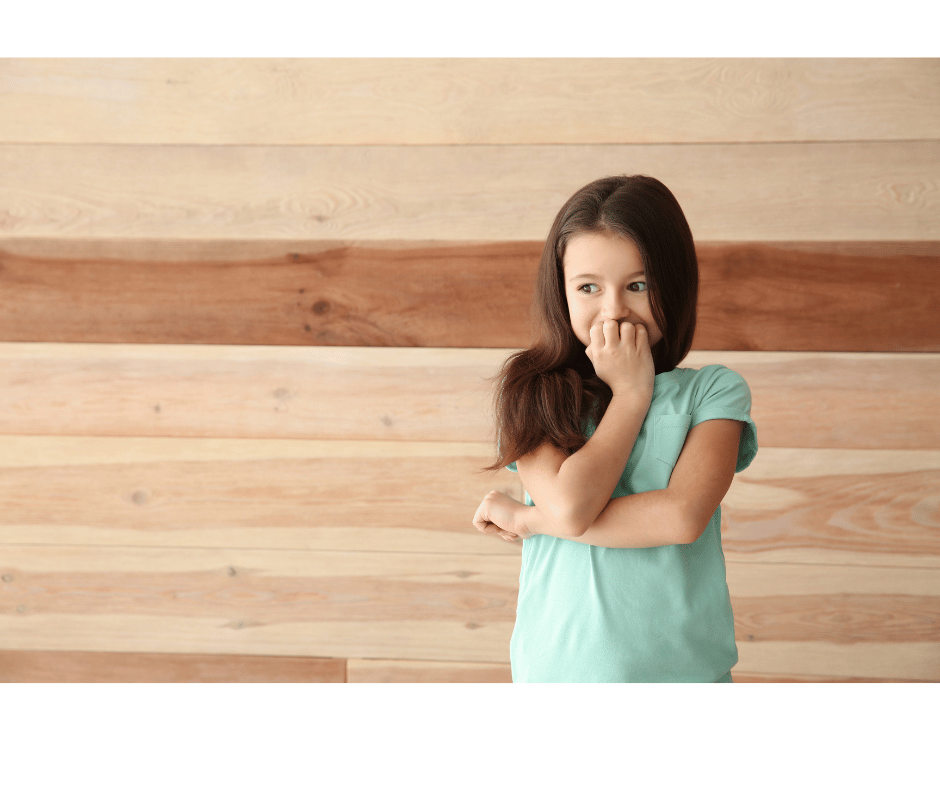 Young girl crossing her arms and covering face with her hand, ashamed.