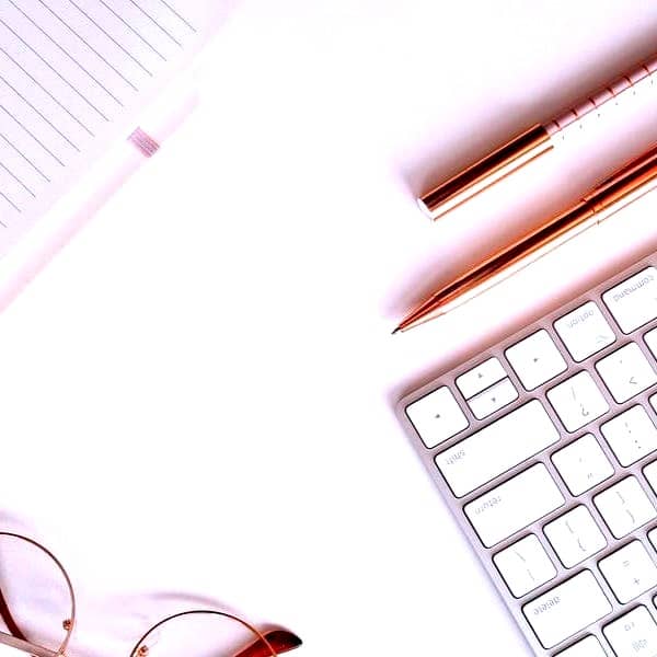 pen near black lined paper and eyeglasses