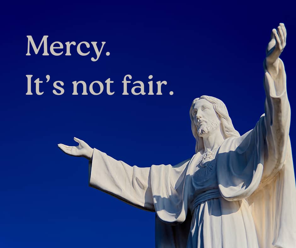 Dark blue sky with white marble Jesus with arms stretched out. Words "Mercy. It's not fair."