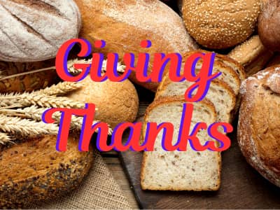 The words Giving thanks in Red over piles of bread and wheat