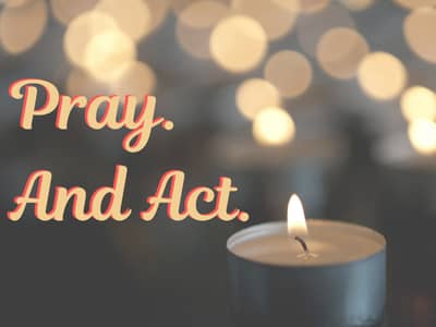 the words Pray and Act over a single votive and reflections of the flame in the background