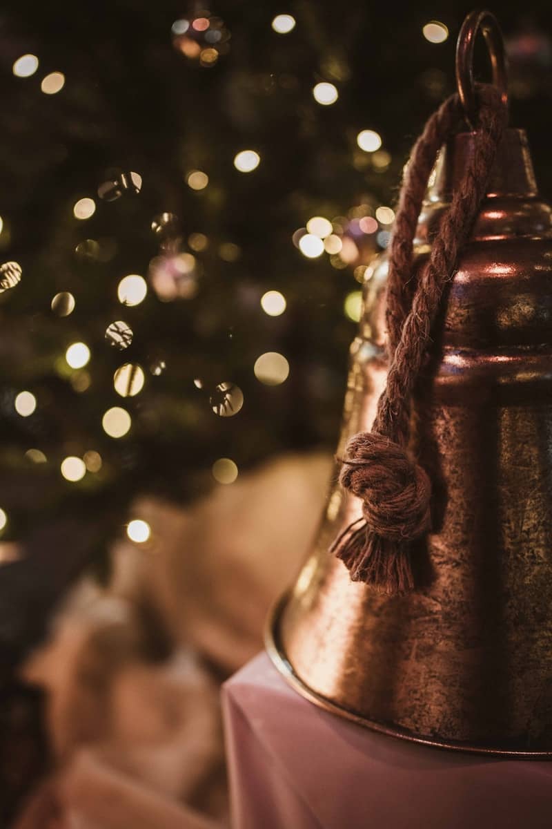 Close-up of brass bells with bokeh christmas lights