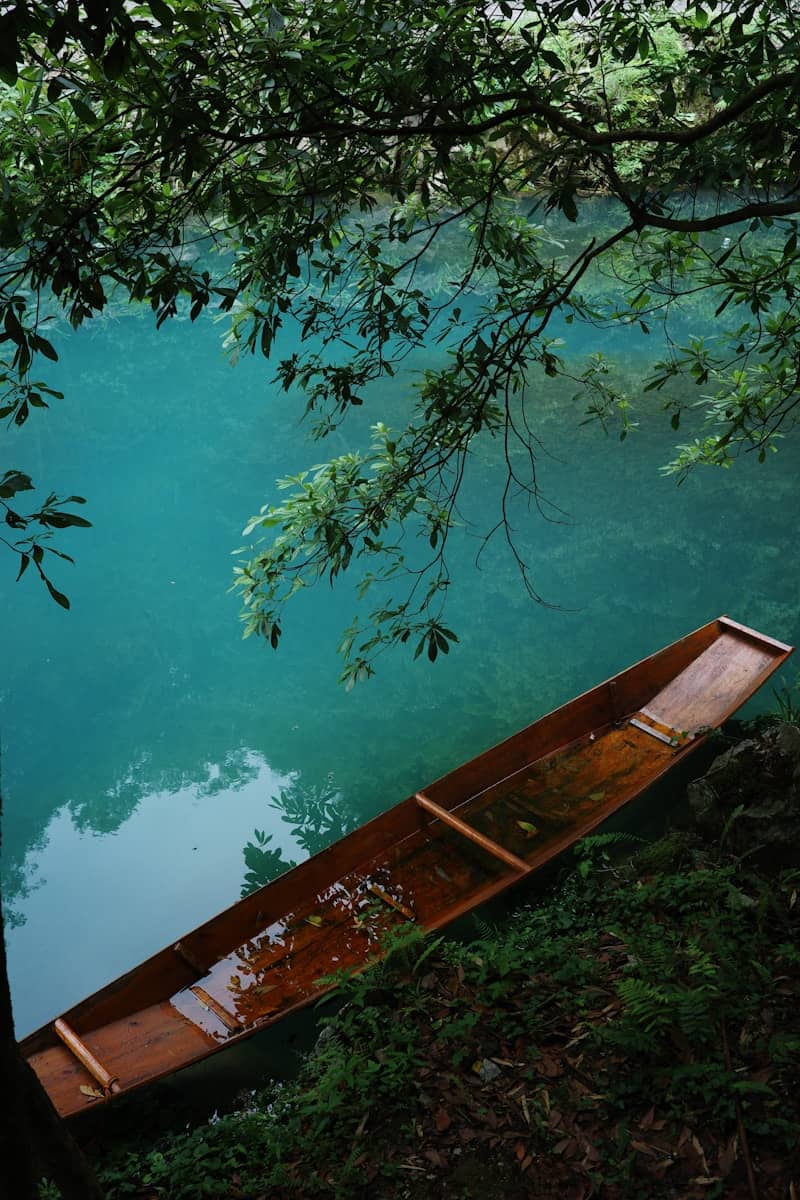 A wooden boat rests on a tranquil lake.