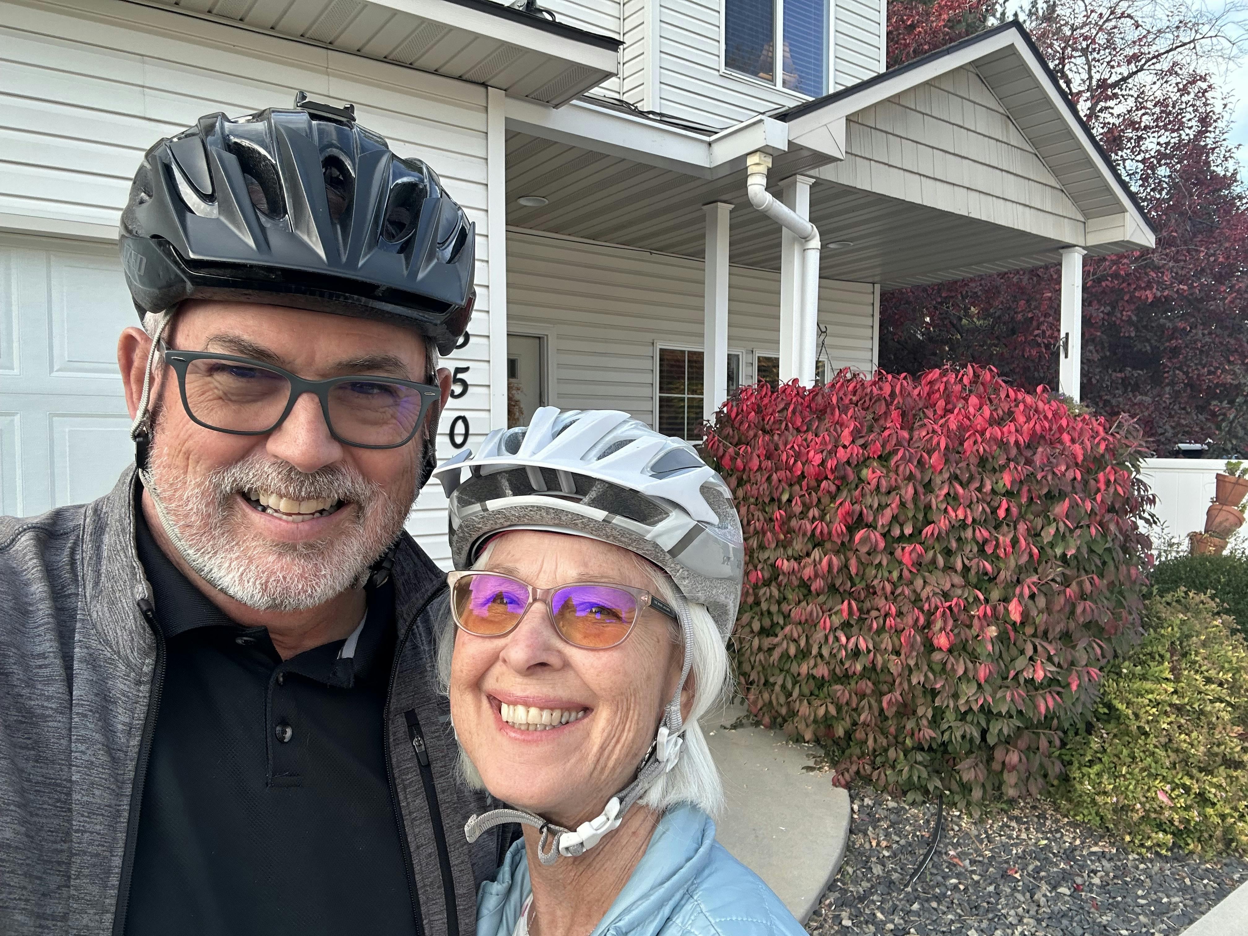 Dennis and Susan Mansfield wearing bicycle helmets outside their house