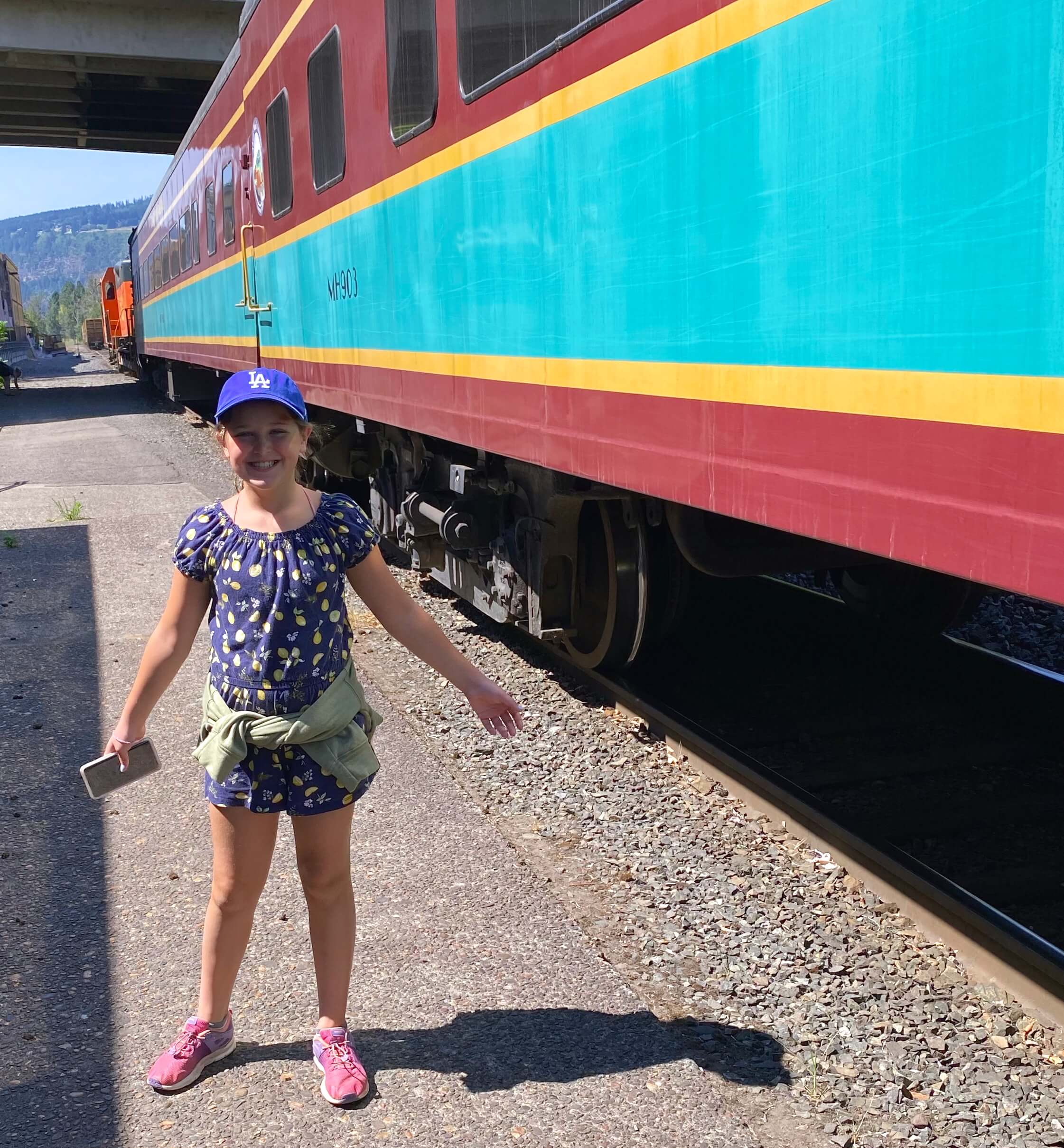 Granddaughter Amelia standing by a train