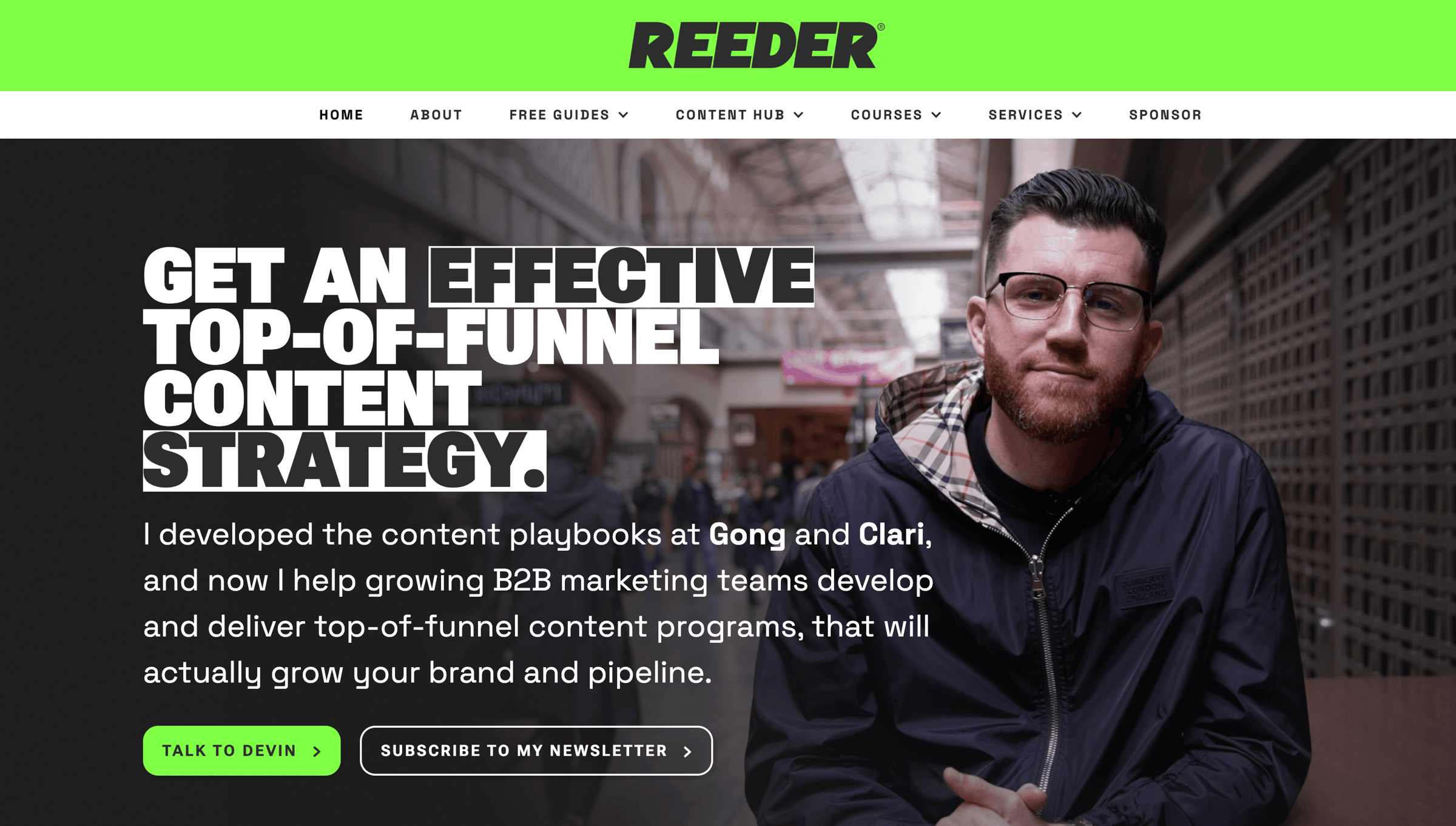 A screenshot of The Reeder’s new website homepage. The header features the logo “REEDER” in bold black font with a green accent at the top. The headline reads: “Get an Effective Top-of-Funnel Content Strategy.” Below the headline, there’s supporting text: “I developed the content playbooks at Gong and Clari, and now I help growing B2B marketing teams develop and deliver top-of-funnel content programs that actually grow your brand and pipeline.” Two call-to-action buttons are visible: one says “Talk to Devin,” and the other says “Subscribe to My Newsletter.” The background shows an image of Devin Reed seated at a table in an urban setting.