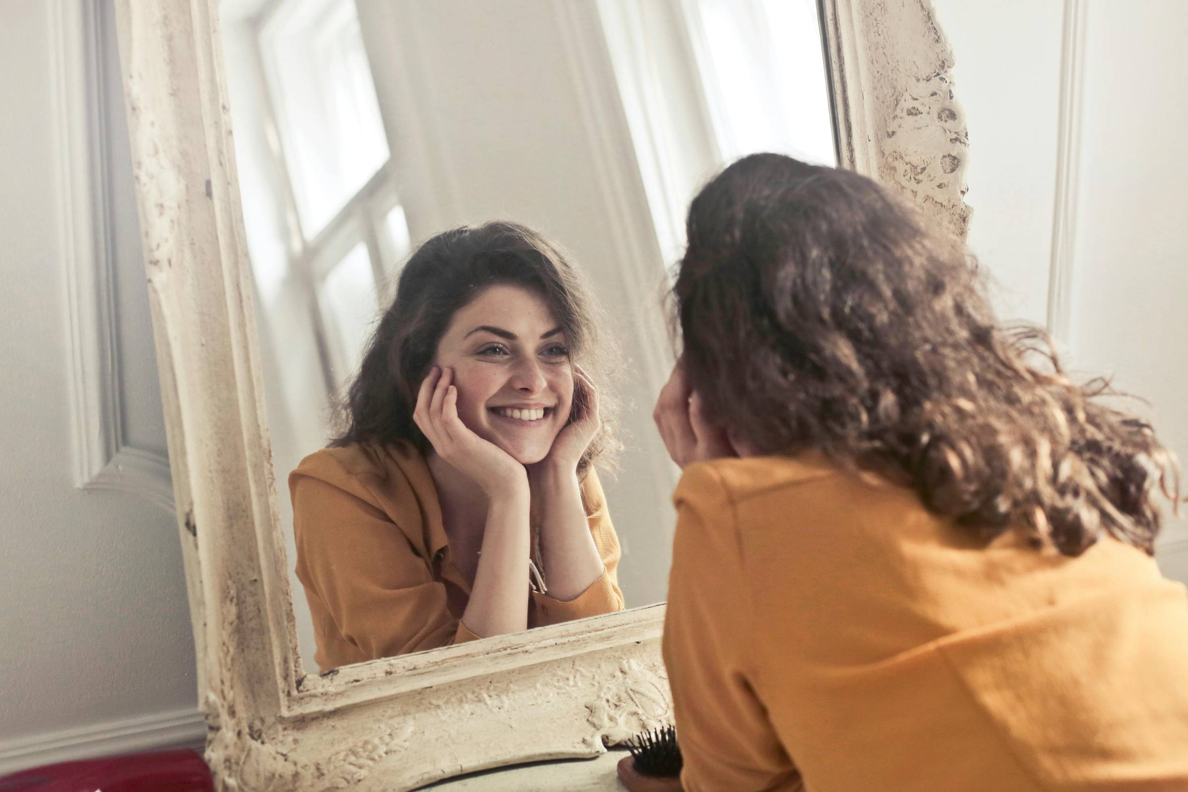 A woman looking in the mirror at herself