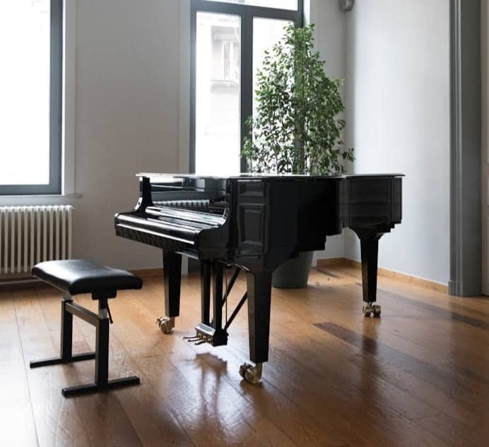 brown grand piano inside white room