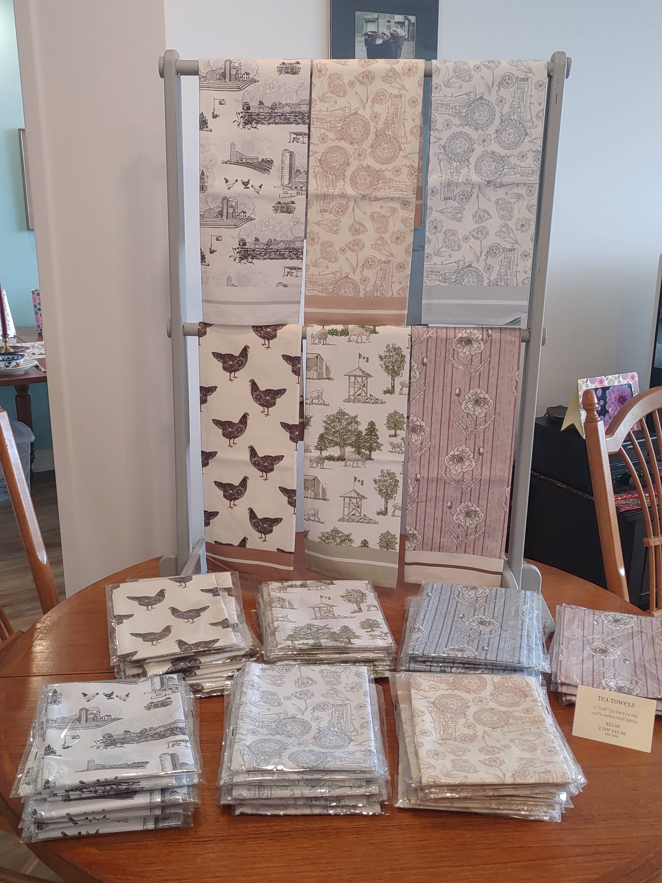A display features 6 original designs by Katherine Moffat, Stonetown Studio on tea towels.