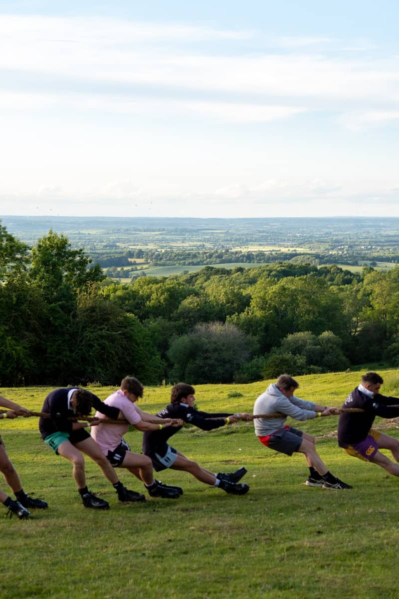 People are playing a game of tug-of-war outside.