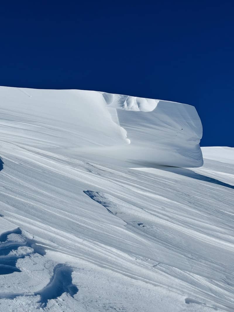 Snowy mountain slope with a clear blue sky