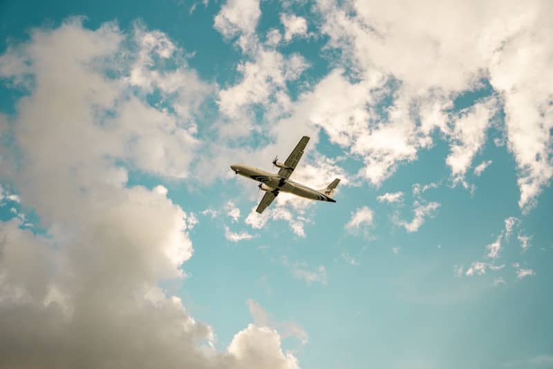 Airplane flying high in the beautiful, cloudy sky.