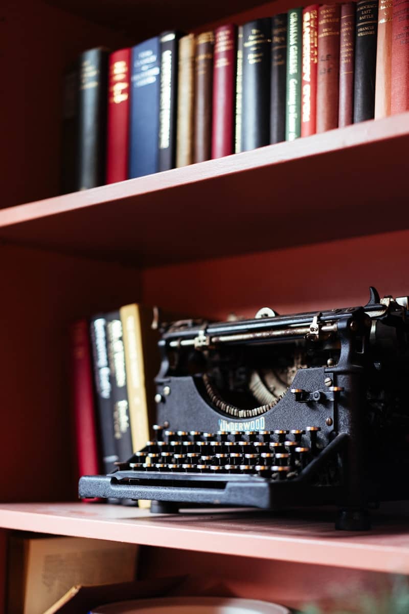 Vintage typewriter on a shelf with books