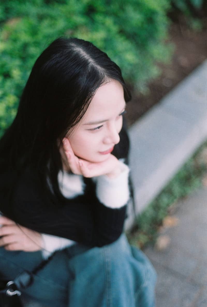Young woman with long dark hair resting chin