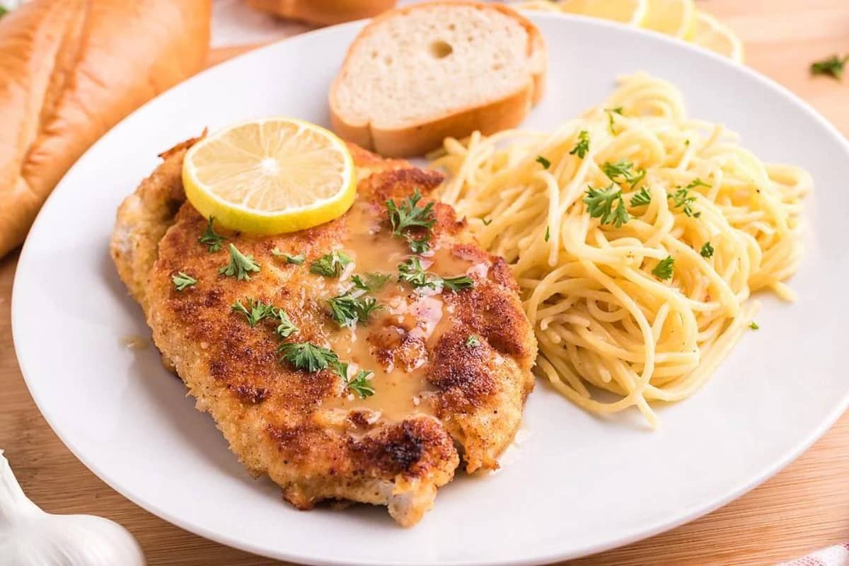 Chicken Scallopine with a side of pasta and lemons.