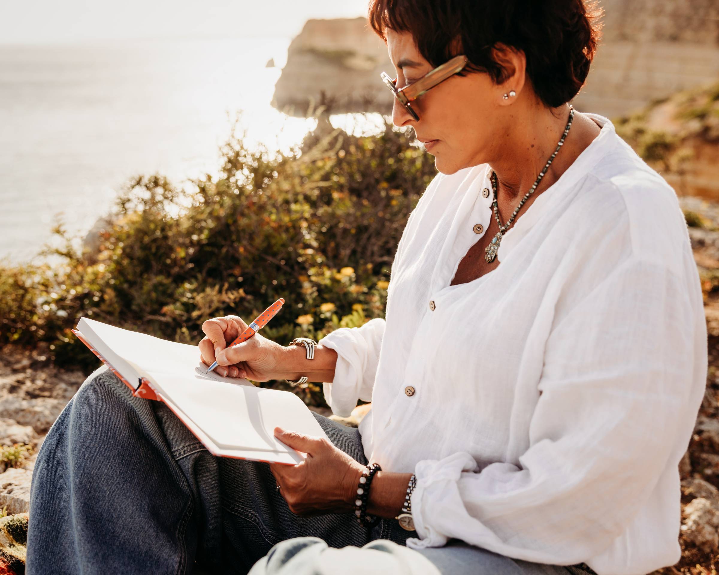 Alicia M Rodriguez author writing on Algarve cliffs