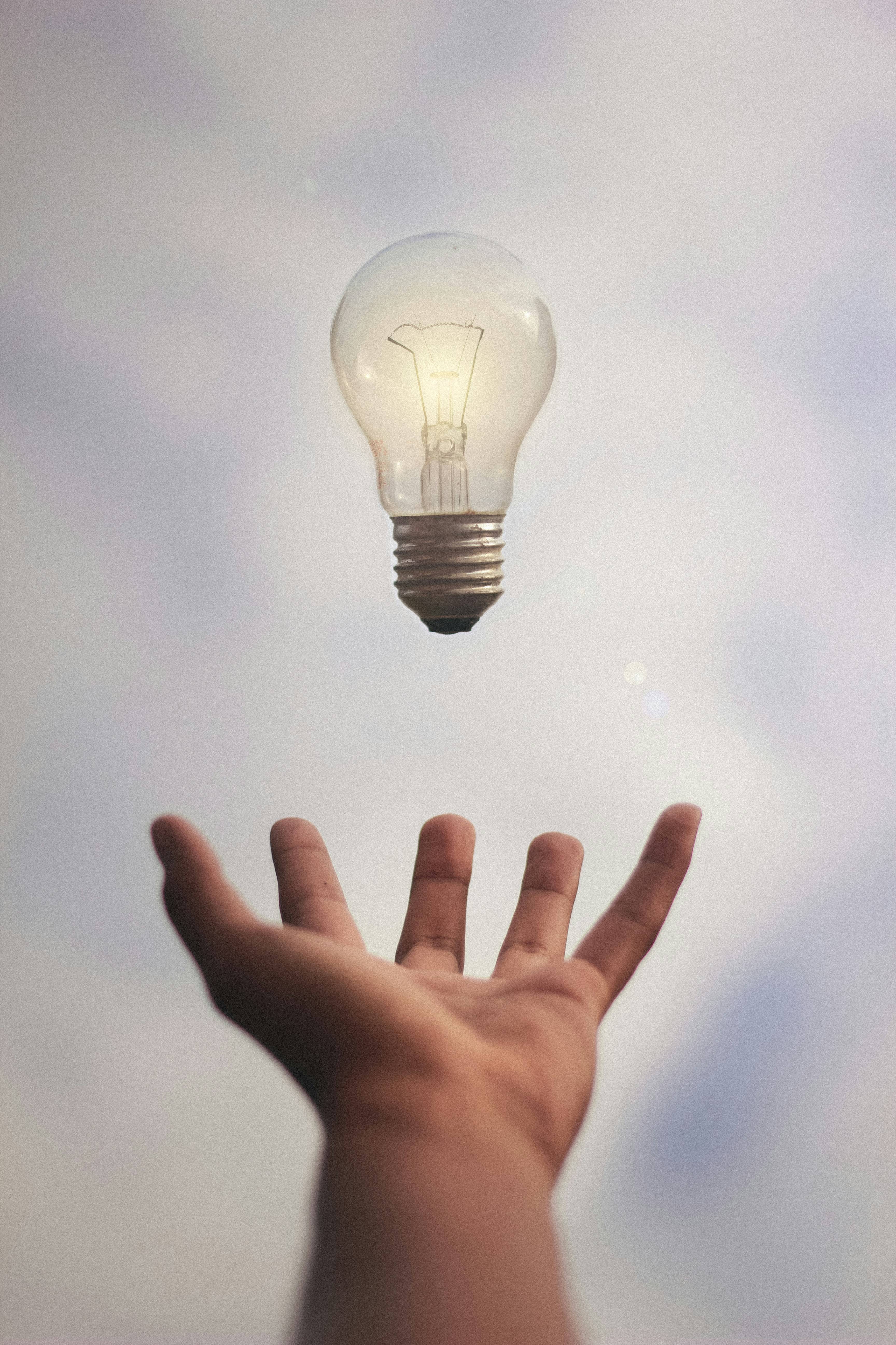 Light bulb hovering over hand