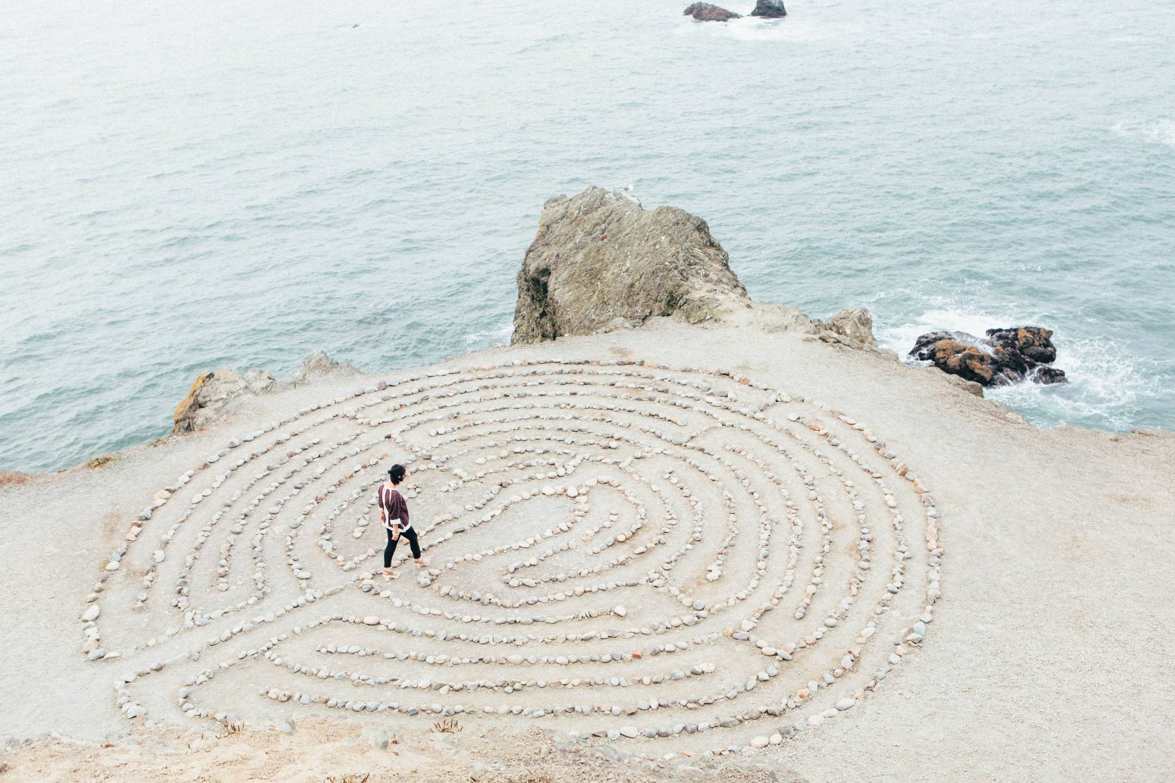 a person walking a labyrinth by the ocean
