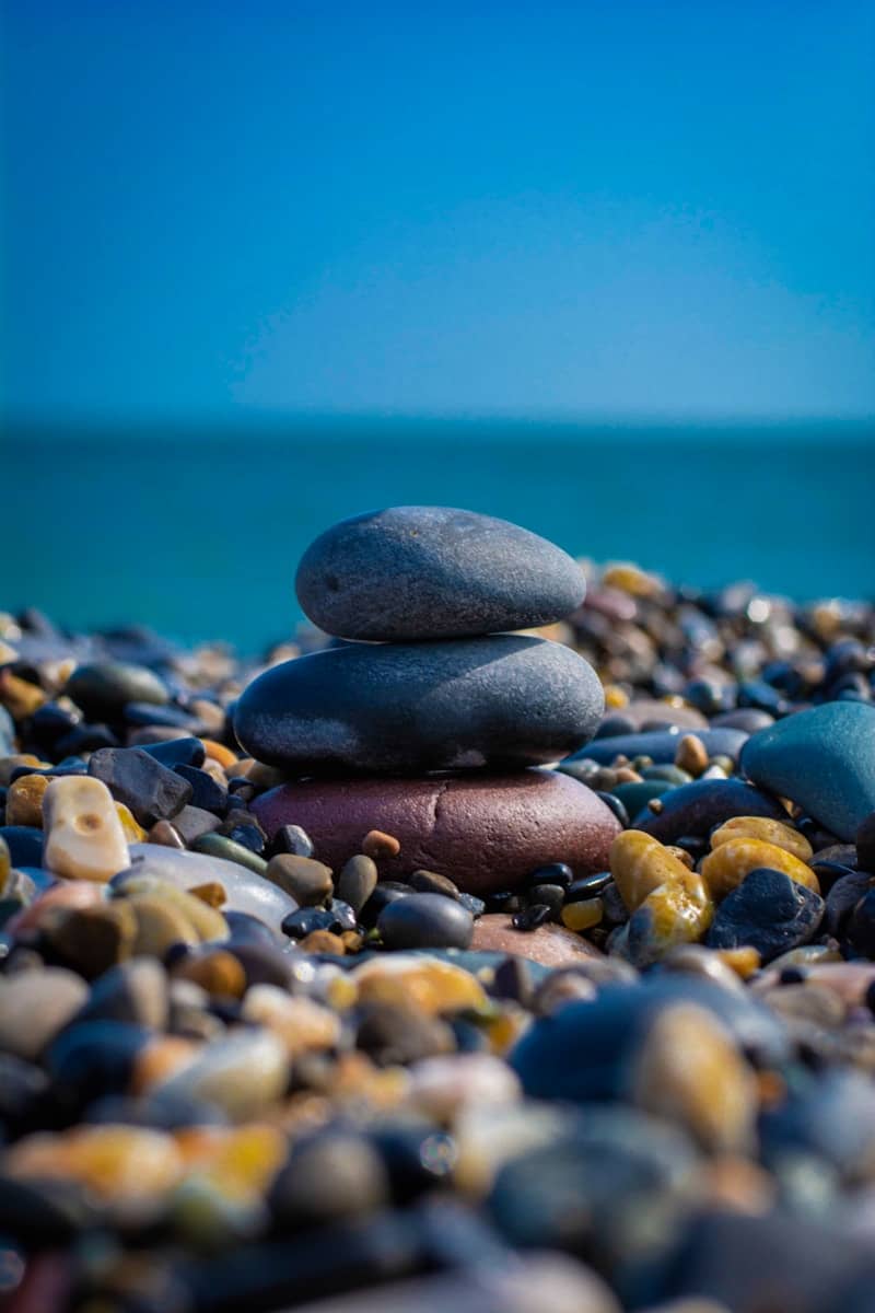 Stacked stones on a pebble beach with ocean background