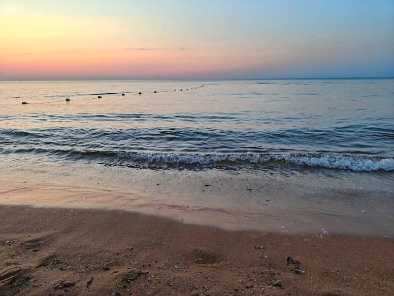 Sunset over the ocean, with a calm, serene view.