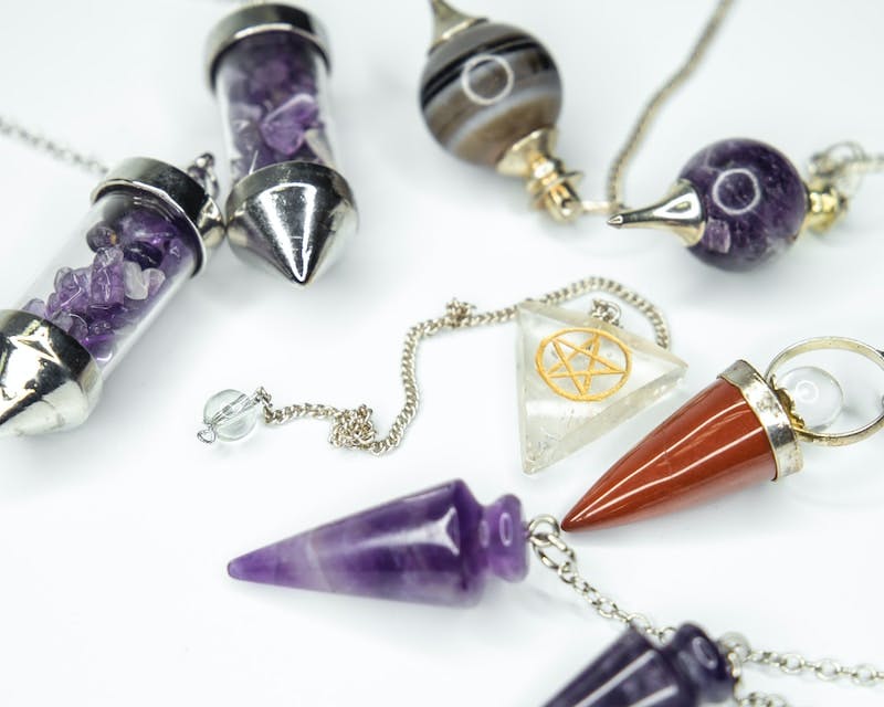 gold and silver necklace and purple stone pendant