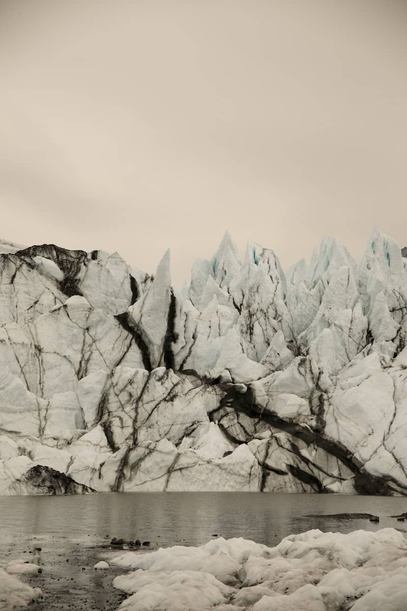 Jagged ice formations on a glacier face above water