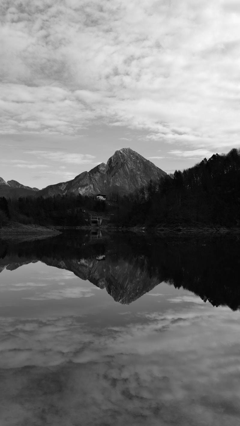 Mountain reflected in a calm lake under cloudy sky