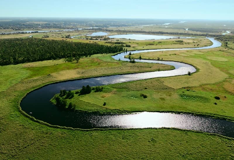 A winding river flows through a lush green landscape.