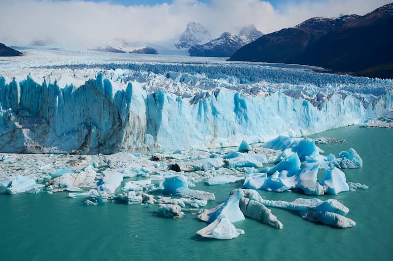 Massive glacier with turquoise water and floating icebergs