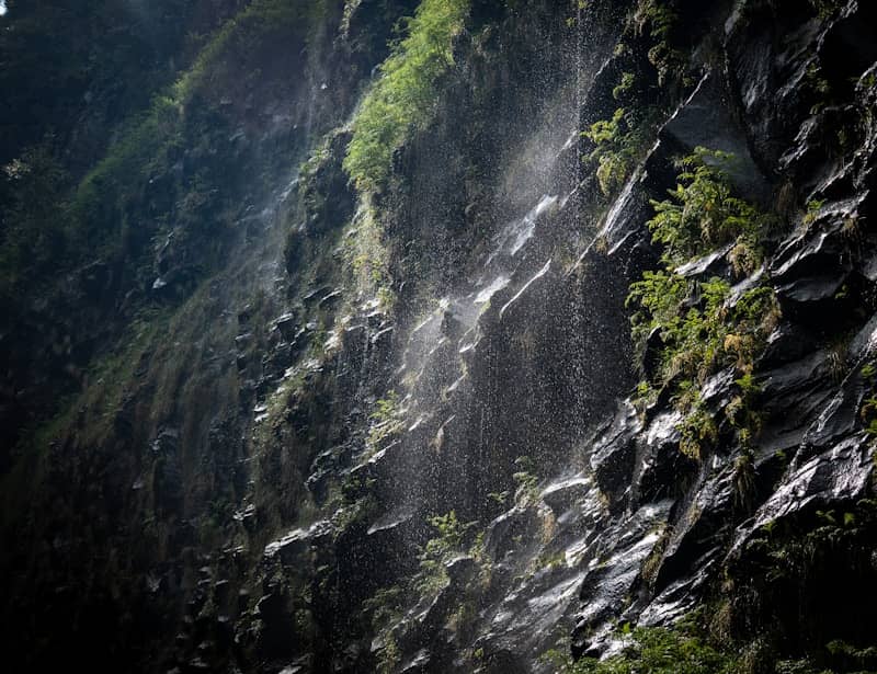 Water cascades down a rocky cliff face.