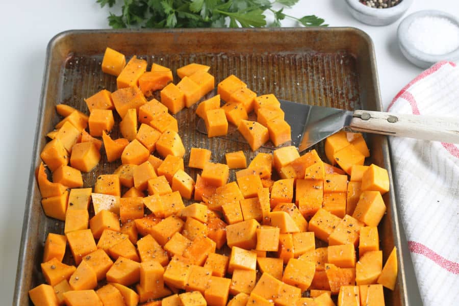 Cubes of butternut squash on a baking sheet