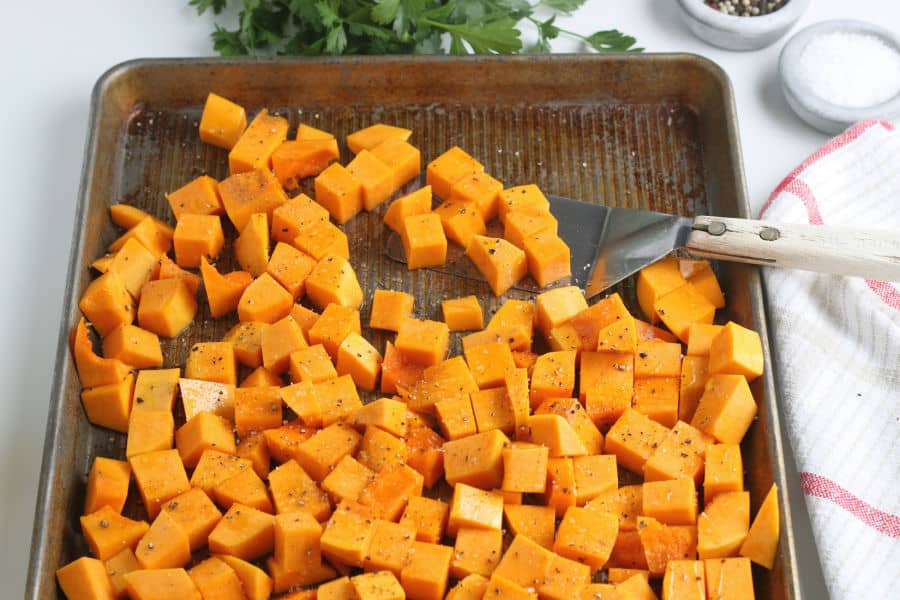 Cubes of butternut squash on a baking sheet