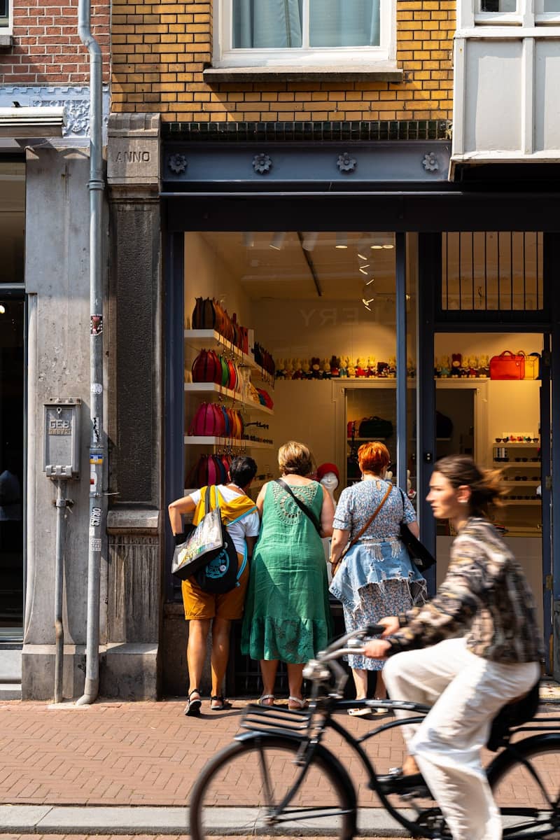 A man riding a bike past a store front